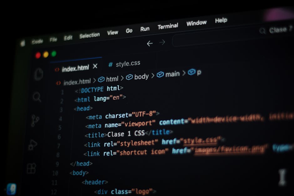 A computer screen displaying a coding editor with HTML code visible on the monitor. The code includes tags such as <html>, <head>, <title> and <link>, with syntax highlighting 